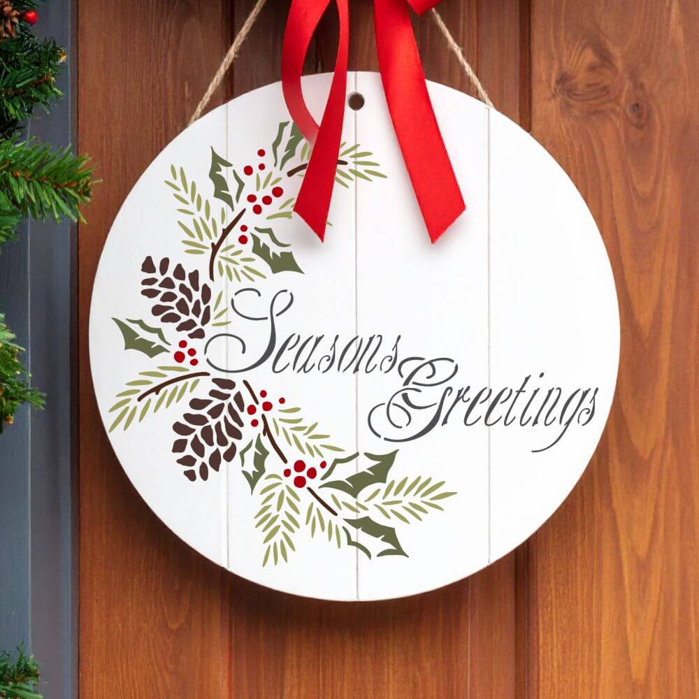 Decorative stencil round sign with 'Seasons Greetings' and holiday greenery, perfect for Christmas home decor.